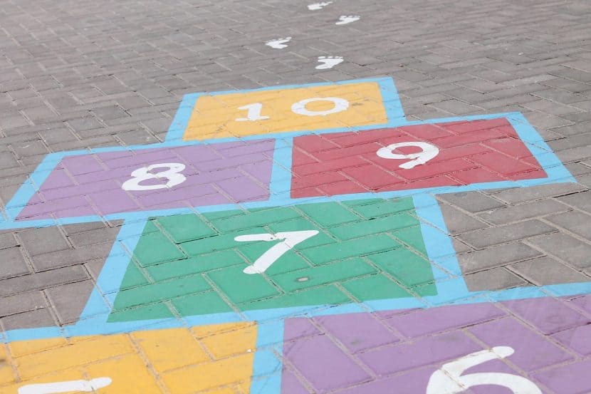 A hopscotch grid on a brick surface topped by the square for "10."